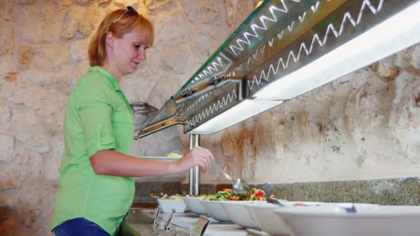 Vrouw kiest groenten in een café met zelfbediening — Stockvideo