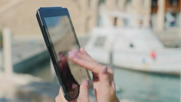 Använda tabletten mot bakgrund av havet och yacht — Stockvideo