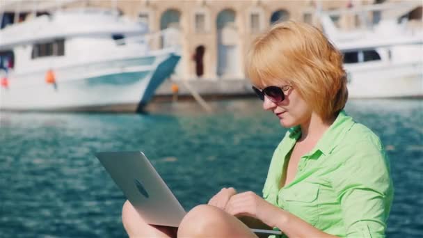 Attraktiver Tourist mit Sonnenbrille genießt einen Laptop — Stockvideo