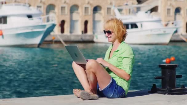 Turista mujer hablando en el chat de vídeo con un ordenador portátil — Vídeos de Stock