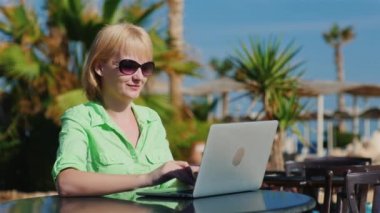 Kadın güneş gözlüğü rekreasyon alanları arka üstünde a laptop sahiptir