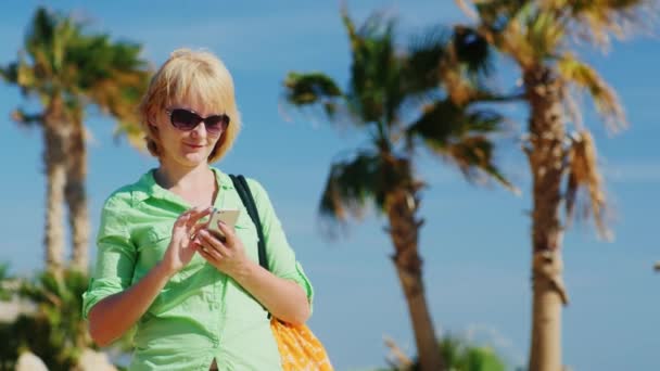 Vrouw in zomer kleren te typen op uw telefoon — Stockvideo