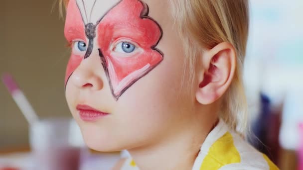 Aplicar maquillaje del niño en forma de mariposas — Vídeo de stock