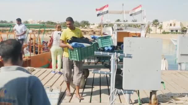 Hurghada, Egipto - 26 de febrero de 2016 Los hombres descargaron cajas de equipo de buceo a bordo — Vídeos de Stock