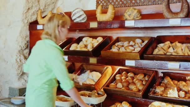 Aantrekkelijke vrouw kiest brood in het café met zelfbediening — Stockvideo