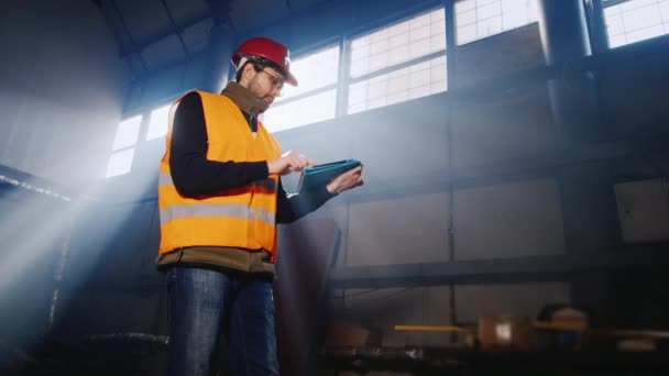 Инженер, работающий с планшетом на складе или на заводе — стоковое видео