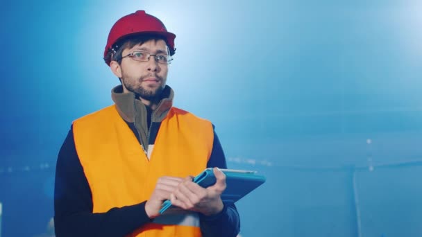 Builder works with the tablet, blurred blue background — Stock Video