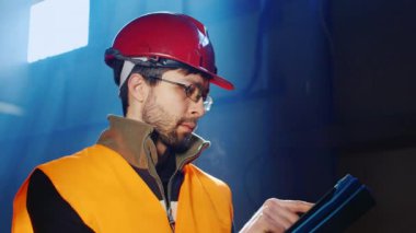Tulum ve kask işçi bir tablet kullanır
