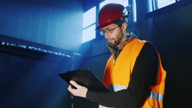 Bir mühendis bir kask içinde portresi: tablet ile çalışır