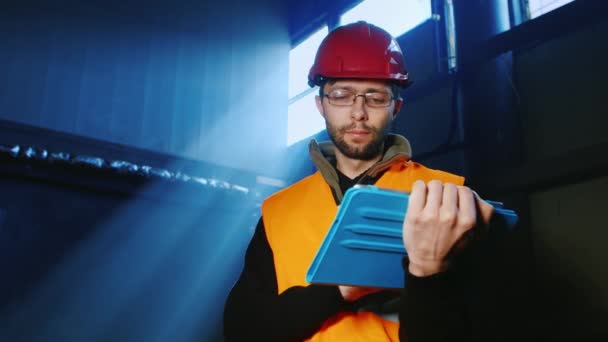 Bir mühendis bir kask içinde portresi: tablet ile çalışır — Stok video