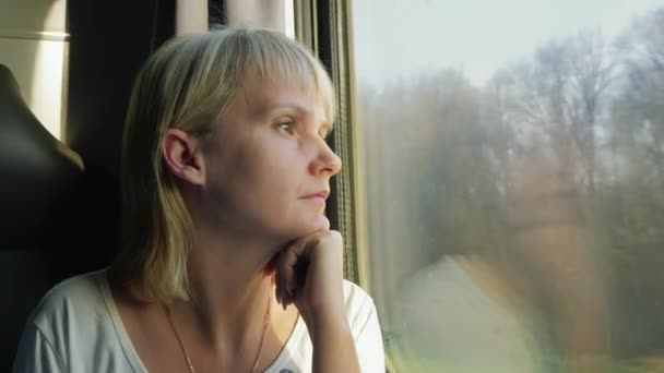 Une femme regarde par la fenêtre du train — Video