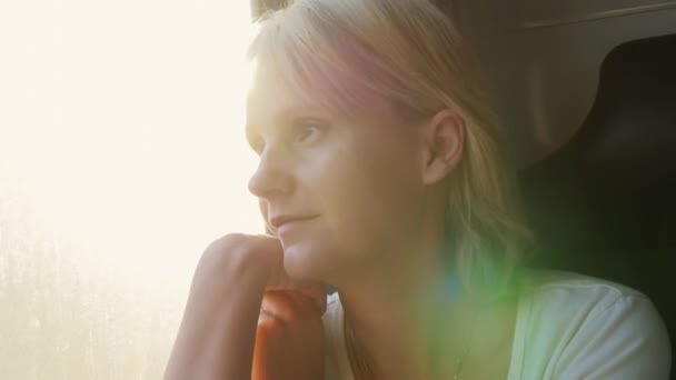 Flashs de soleil sur les femmes visage qui regarde dans la fenêtre du train pendant le trajet — Video