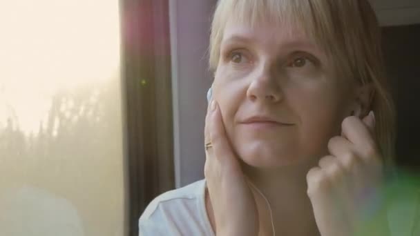 Sol e música - mulher ouvindo música em um trem — Vídeo de Stock