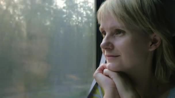 Portrait of a woman traveler, looking to the train window — Stock Video