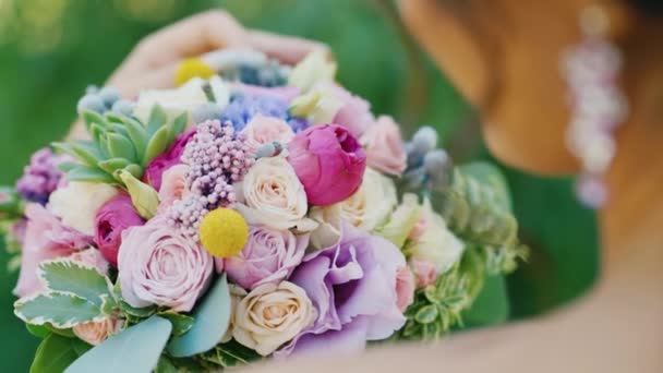 Bride looking at bouquet, view over shoulder — Stock Video