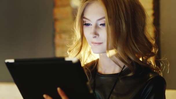 Hermosa joven disfrutando de una tableta en un café — Vídeo de stock