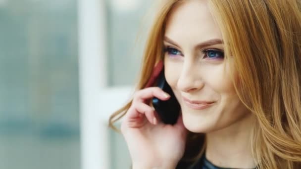 Hermosa mujer con el pelo largo, hablando por teléfono al aire libre — Vídeo de stock