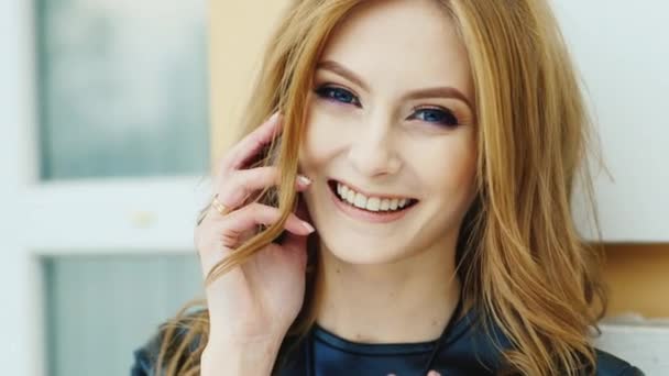 Hermosa mujer de ojos azules habla en un teléfono móvil — Vídeos de Stock