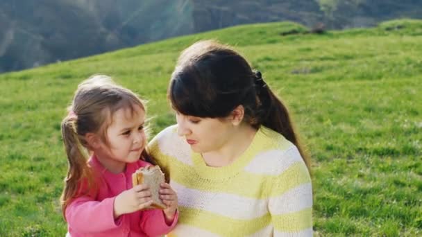Забавная маленькая девочка пытается накормить мою мать сэндвичем — стоковое видео
