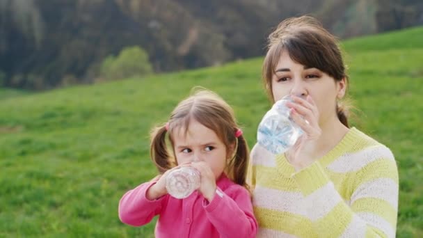 Matka i córka, pić czystą wodę z plastikowych butelek — Wideo stockowe