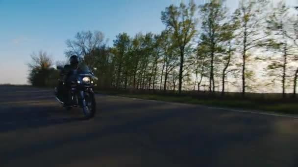 Motocykl jeździ na drodze, w niskim punkcie fotografowania — Wideo stockowe