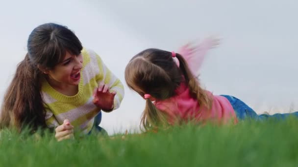 Moeder en dochter spelen op het gras — Stockvideo