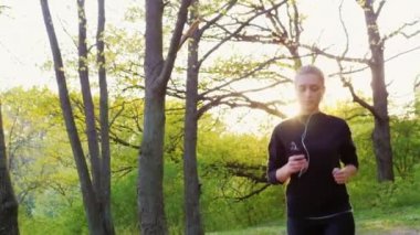 Steadicam yavaş vurdu: ormanda çalışan genç bir kadın. Sağlıklı yaşam ve spor