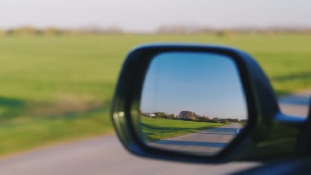 The car ahead of the motorcycle, the view through the rear-view mirror — Stock Video