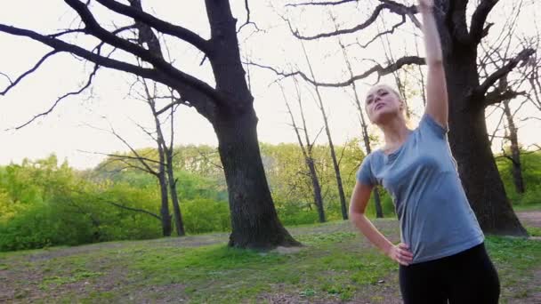 Parkta egzersiz yapan genç bir kadın. — Stok video