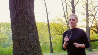 Steadicam yavaş vurdu: çekici bir genç kadın bir sabah ormanda koşu yapar. Güneş güzel parlıyor ve bir parlama verir