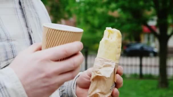 不健康的食物，时间仓促。与咖啡和三明治手 — 图库视频影像