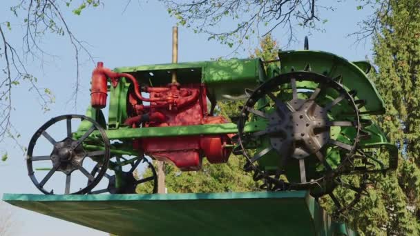 The old tractor on a pedestal - a monument to the tractor — Stock Video