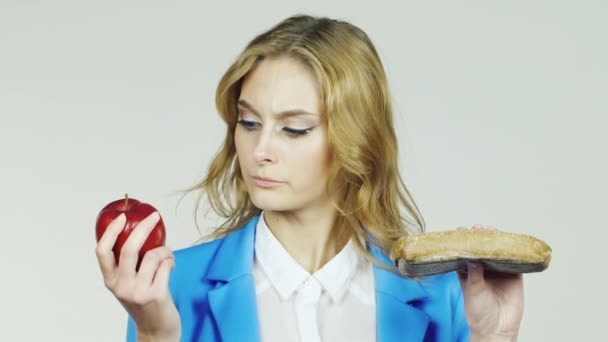 Mulher com maçã e uma sanduíche. Conceito - escolhas alimentares saudáveis — Vídeo de Stock