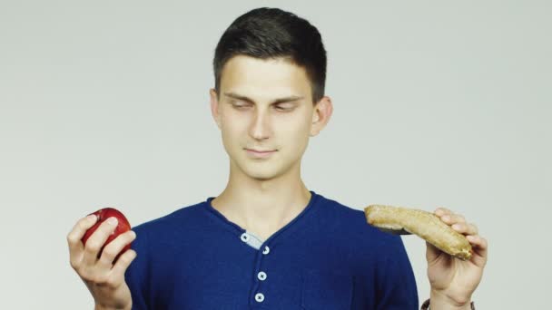 Un hombre con una manzana y un sándwich — Vídeo de stock