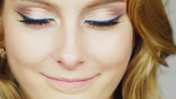 Retrato de una joven mujer de ojos azules acariciando su cara con las yemas de sus dedos — Vídeos de Stock