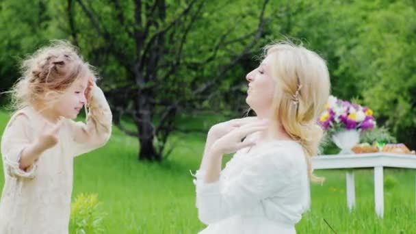 The woman has fun with 4-5 years girl on a green lawn — Stock Video