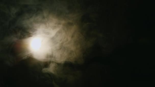 Spotlight included in the cloud of smoke on a black background — Stock Video