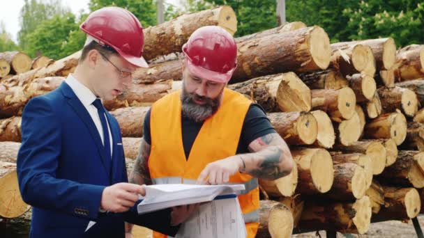 Construtor e engenheiro barbudo trabalham em conjunto com documentos de construção e plantas — Vídeo de Stock