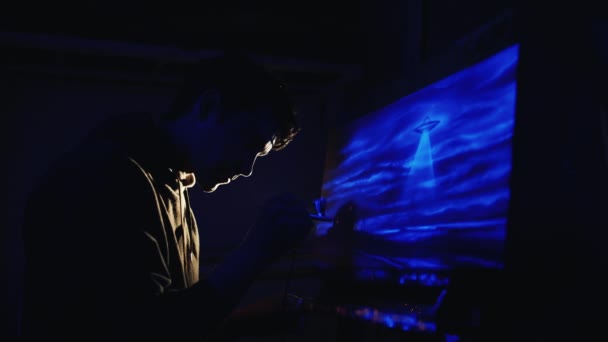 Suluet artist who paints a picture glowing colors. It works under ultraviolet light — Stock Video