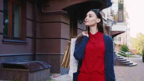 Mujer con estilo con bolsas de compras caminando por la ciudad — Vídeos de Stock