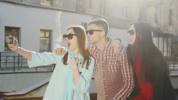 Grupo de jovens amigos - um homem e duas mulheres fazendo selfie — Vídeo de Stock
