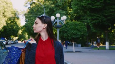 Sokakta yürüyen birkaç alışveriş çantaları ile çekici bir kadın