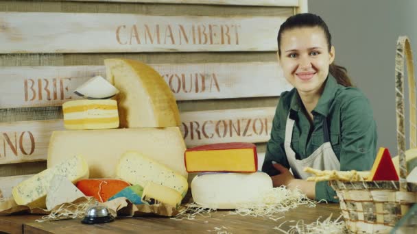 Retrato de atractivo vendedor tienda de queso. Ella mira a la cámara: sonriendo — Vídeos de Stock