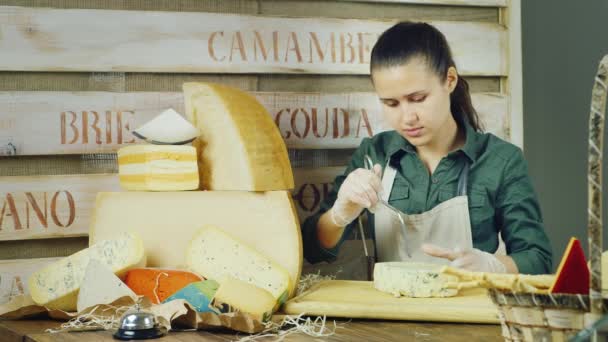 El vendedor en la tienda de queso cortar el queso — Vídeos de Stock