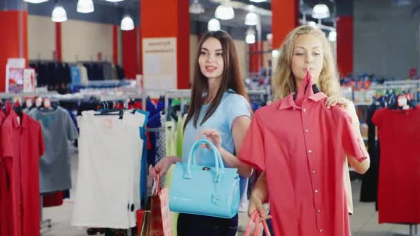 As mulheres olham para o vestido de verão e uma bolsa em um grande espelho — Vídeo de Stock