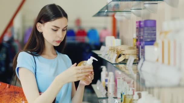 Ελκυστική μελαχρινή επιλέγει υγρό σαπούνι σε ένα κατάστημα αρωμάτων — Αρχείο Βίντεο