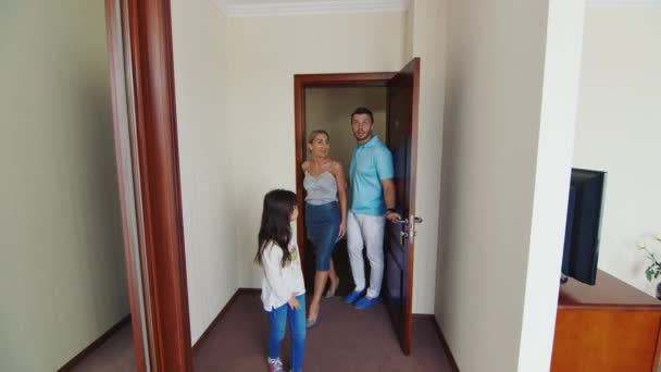 Steadicam výstřel: mladá rodina - máma a táta dcera usadit do svého pokoje. Oni jsou velmi spokojeni s jejich pokoj — Stock video