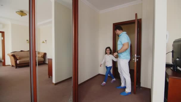 Una giovane famiglia è venuta a riposare nella camera d'albergo. Sono molto felici delle loro stanze, gioiscono — Video Stock