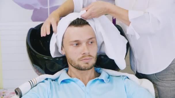 Bärtige junge Männer wischen sich mit einem Handtuch über den Kopf. die Friseure — Stockvideo