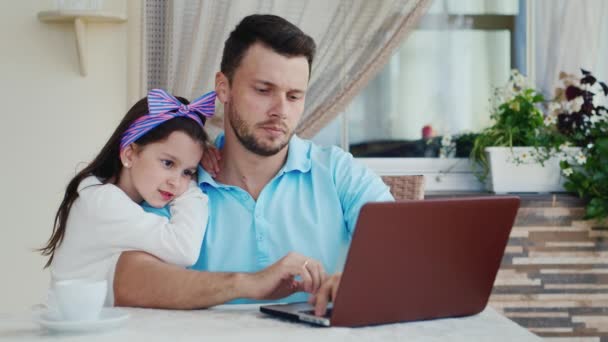 Junger Mann zeigt seiner Tochter, wie man Laptop benutzt — Stockvideo